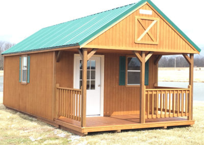 12x20 Classic Lofted Cabin with Green metal roof, optional porch railings, optional steel door with windows, and optional Green shutters.